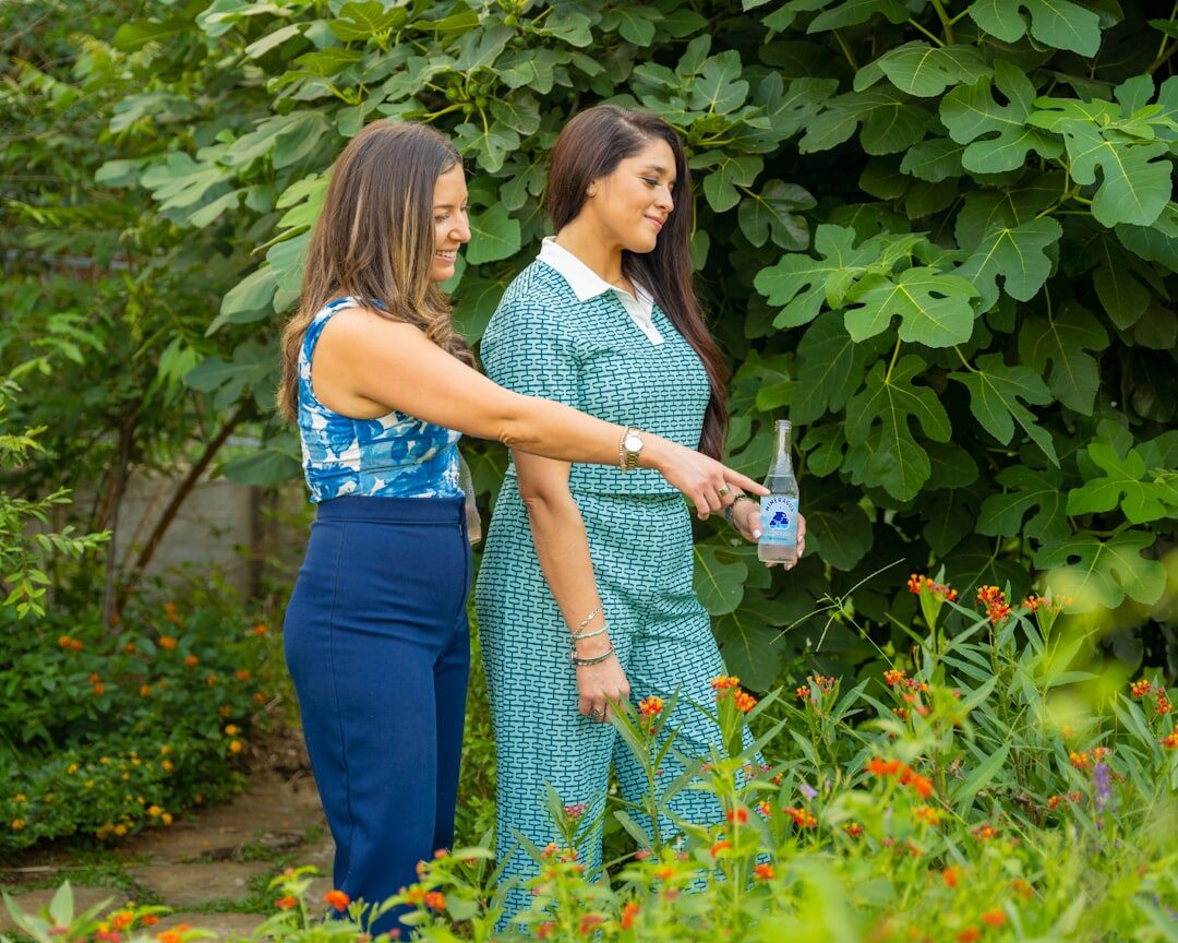Small editorial team of Czech gardening writers reviewing notes in a garden setting